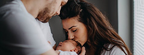 image of a woman kissing her baby's forehead