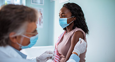 A medical professional giving a shot to a patient