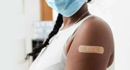 woman showing off post-shot band-aid on arm