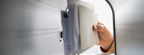 image of a hand pulling mail out of the mailbox