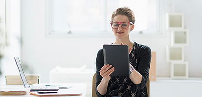 smiling woman using her tablet for an AHN telehealth visit