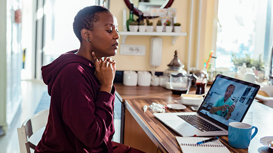 woman explaining her symptoms during a telehealth video visit with her doctor
