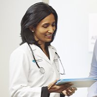 AHN physician smiling as she reviews lab results with patient