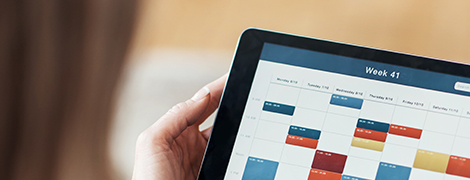 image of a woman looking at a schedule on a tablet