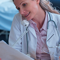 image of a doctor on the phone looking at a chart