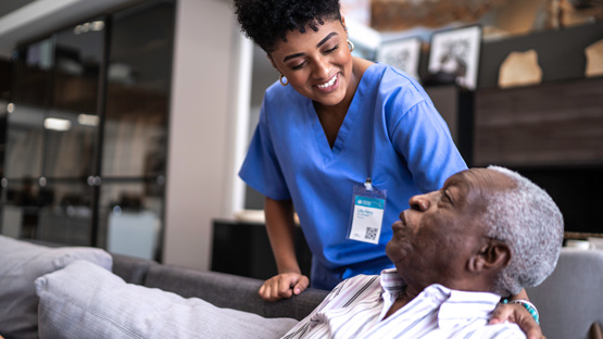 female nurse smiling and conversing with an elderly male patient