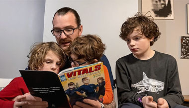 AHN Nurse reading marvel comic with sons