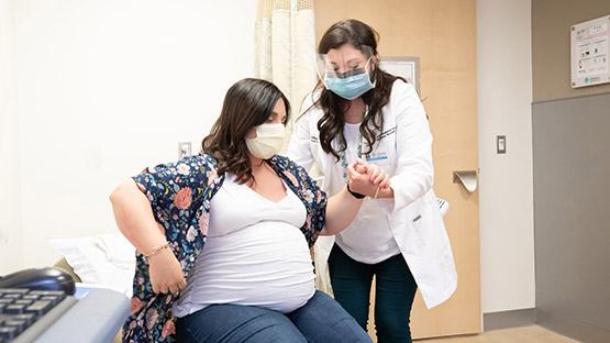 pregnant woman being assisted by a physician during her visit