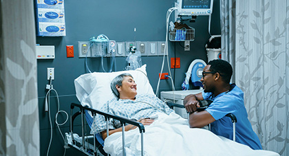 nurse talking to a patient laying in an ER bed