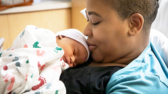 new mother holding her newborn baby against her chest
