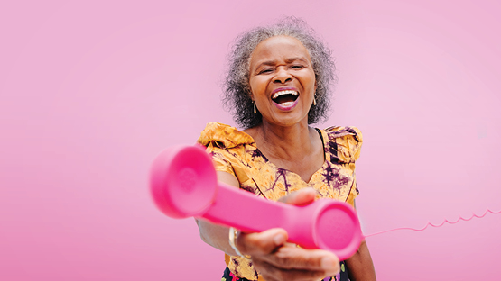women reaching out to the viewer with a pink phone
