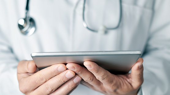 image of a doctor holding a tablet