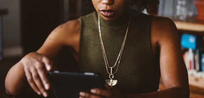 image of woman reading news article on tablet