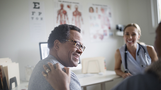 man smiling as he speaks with AHN specialist