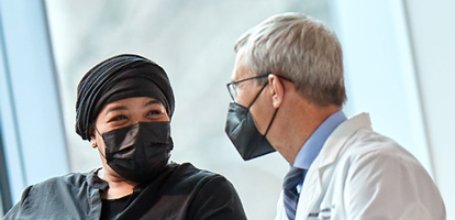 AHN oncologist sitting down and speaking with a cancer patient in a comforting way
