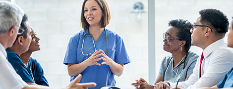 image of a doctor speaking to a group of her colleagues