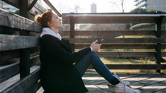 woman sitting on deck contemplating seeking help for intimate partner violence