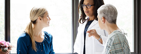 image of a doctor talking to a patient and her colleague