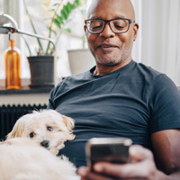 A man with his dog looking at his phone
