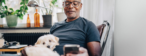 A man with his dog looking at his phone