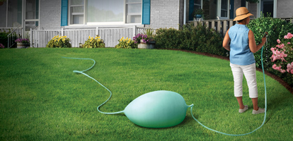 Woman watering flowers ignoring problem with garden hose