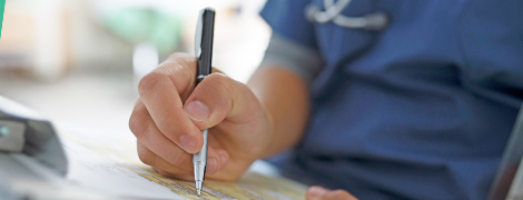 image of a doctor writing on a chart